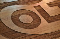Closeup of laser-engraved walnut handgun case.